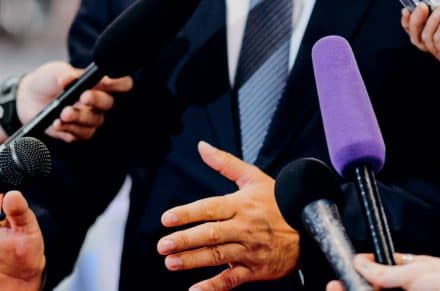 Man speaking in front of microphones