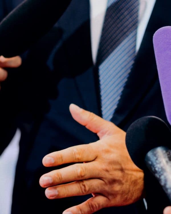 Man speaking in front of microphones